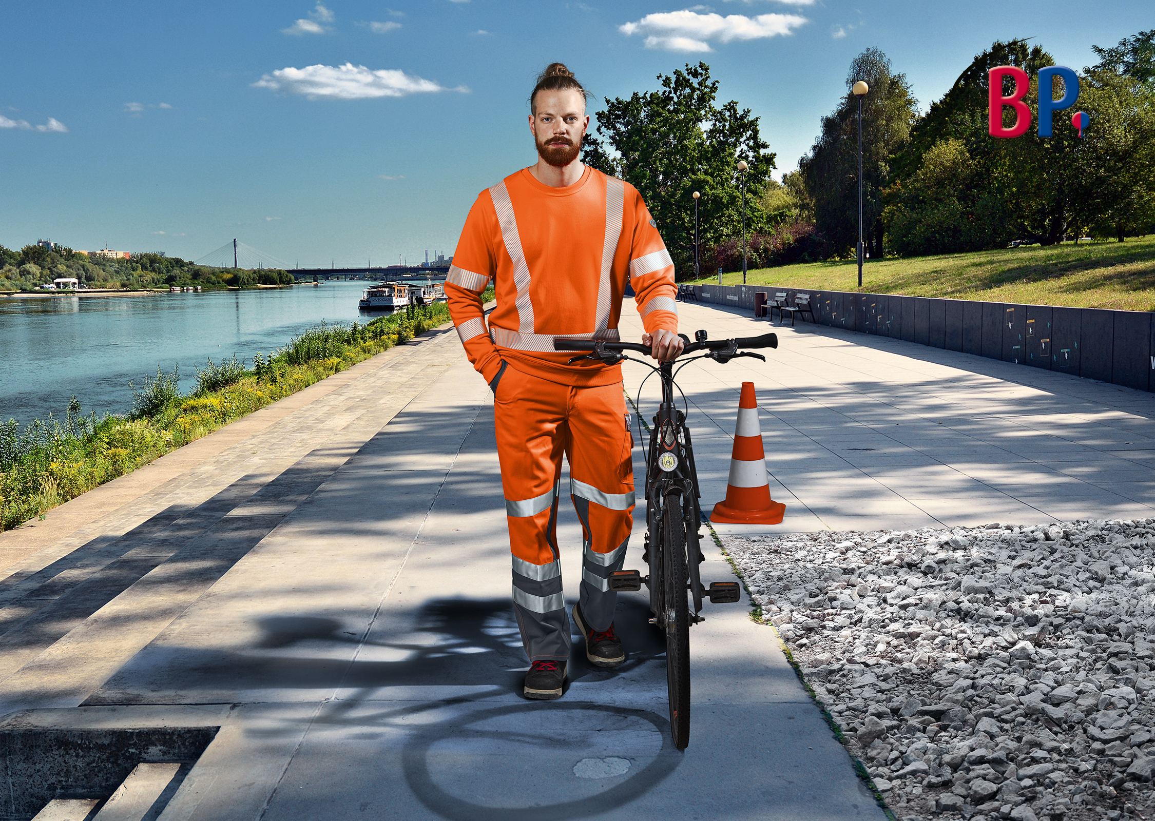 Ein Radfahrer trägt Warnschutzkleidung und hält sein Fahrrad mit der Hand.