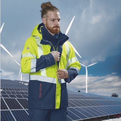 Un homme porte des vêtements de protection BProtected et se tient devant une installation solaire.