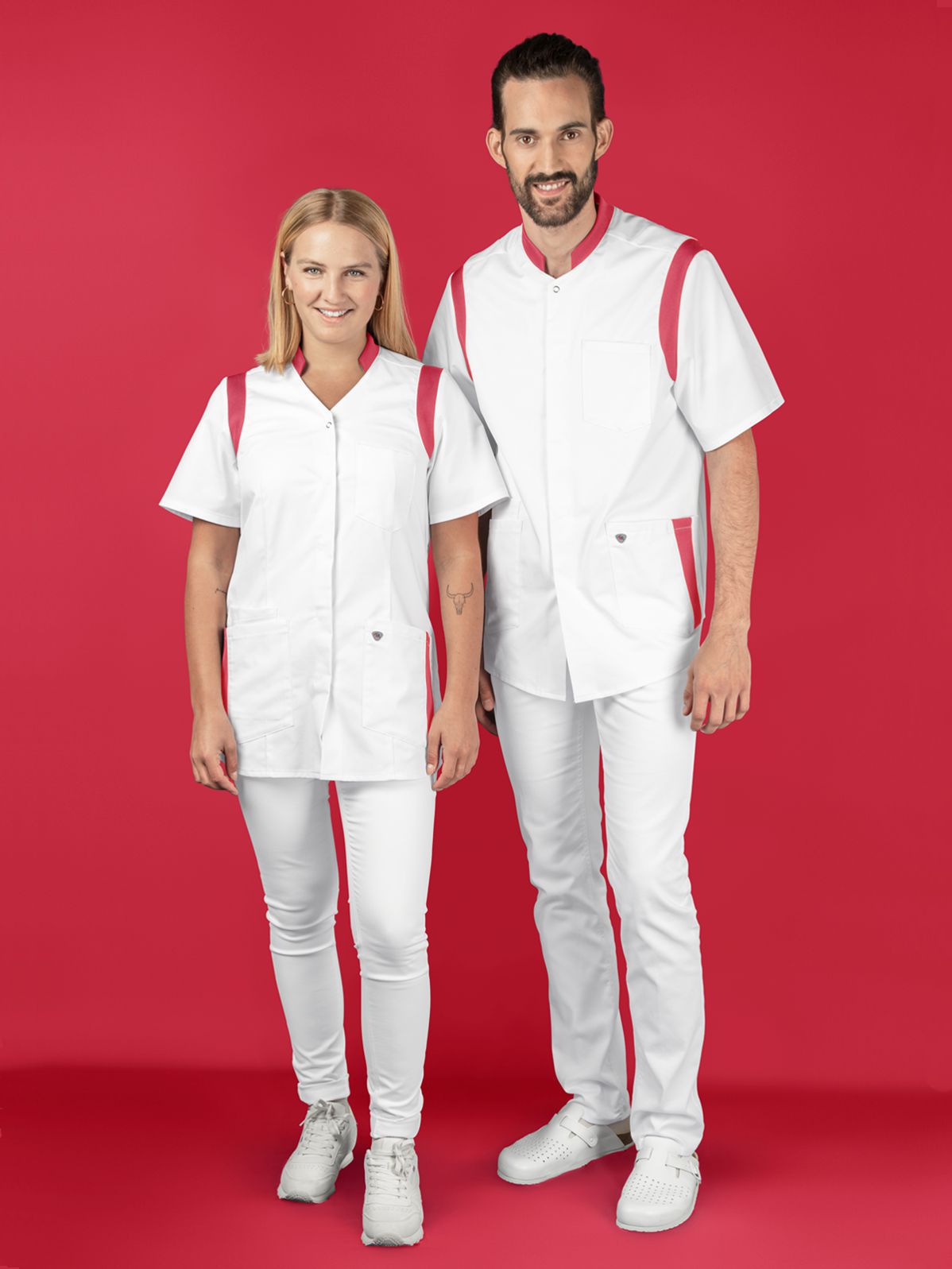 Eine Frau und ein Mann stehen nebeneinander und tragen einen Outfit für Pfleger in weiß.