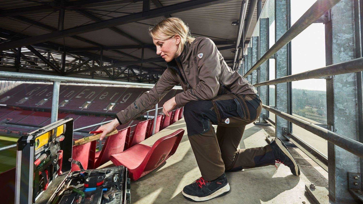 Craftswoman with work clothes in the stadium