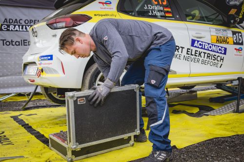 Un employé de service met la main dans une boîte à outils et porte des vêtements de travail BP®.