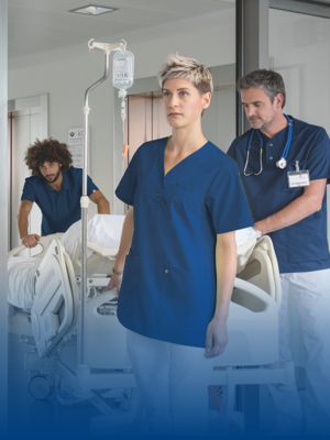 Krankenhauspersonal schiebt einen  Krankenbett mit passender Arbeitsuniform.