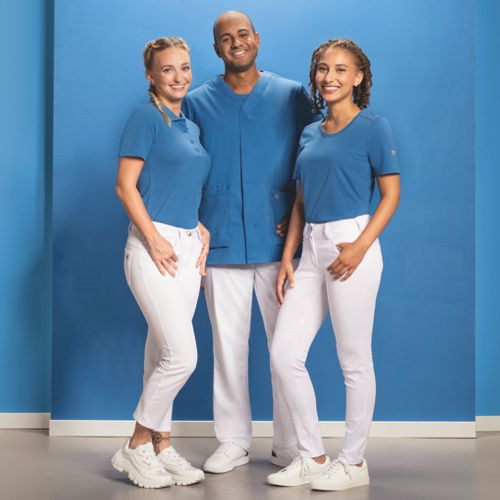 Un infirmier et deux infirmières portent une tenue d'équipe.