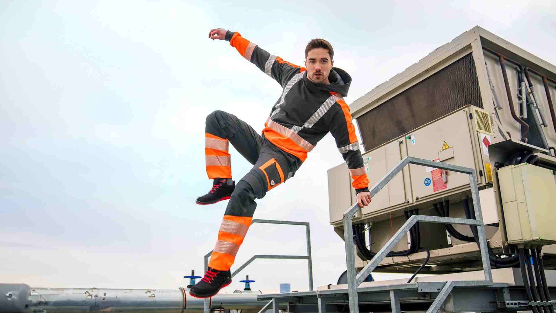 Ein Mann springt eine Treppe runter mit MultiProtectPlus Arbeitskleidung.