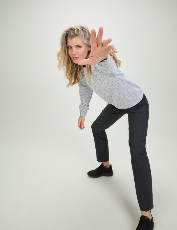 Eine Frau trägt ein graues sweatshirt für Damen und post in die Kamera.