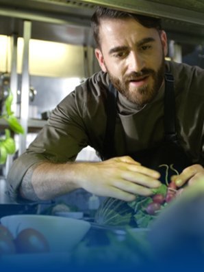 Een chef-kok met een BP® werkshirt staat in de keuken.