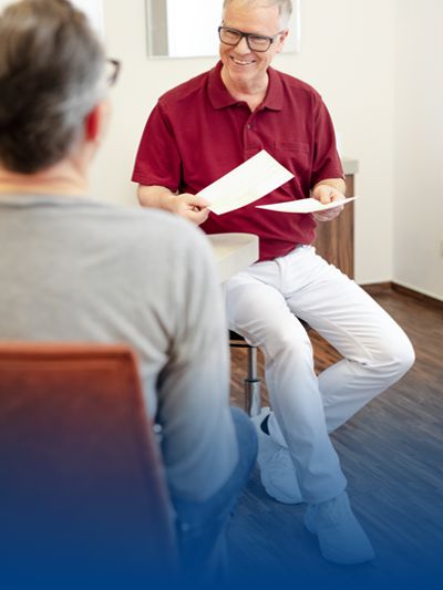 Ein Arzt spricht mit seinem Patienten in einem Praxisoutfit von BP®.