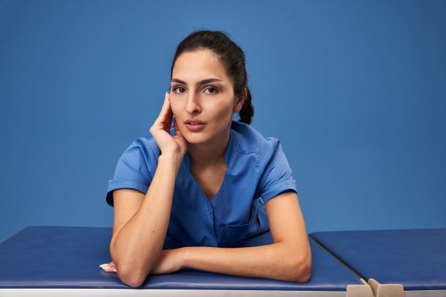 Een verzorger draagt azuurblauwe werkkleding.