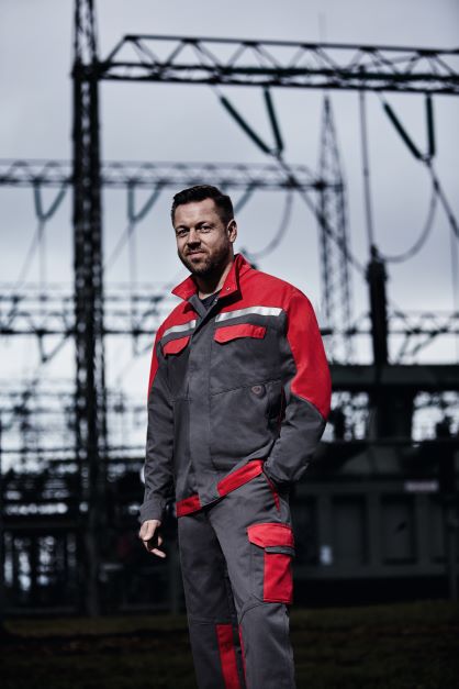 Un artisan en tenue de travail lors d'une installation électrique.