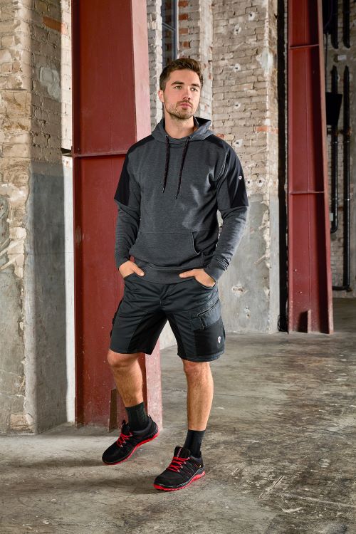 Un homme porte un short de travail BP® sur un chantier.