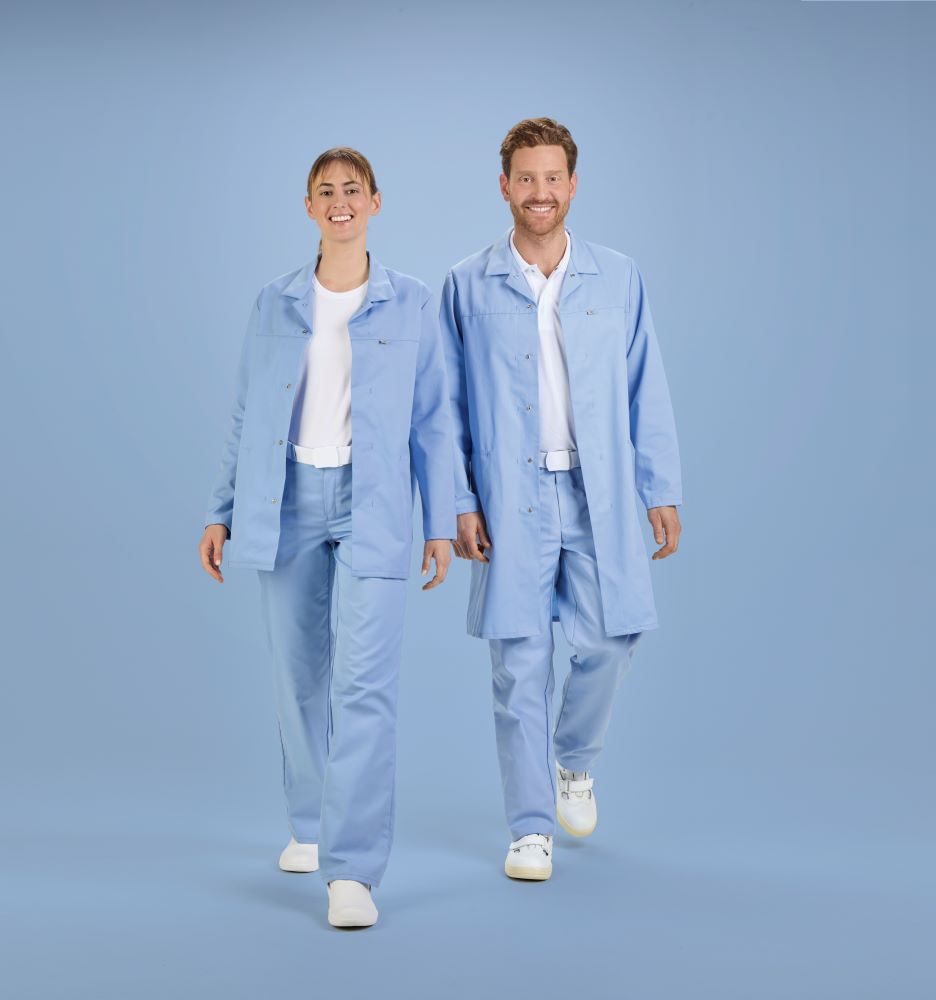 Eine Frau und ein Mann die nebeneinander stehen tragen HACCP Arbeitskleidung in hellblau und lächeln.