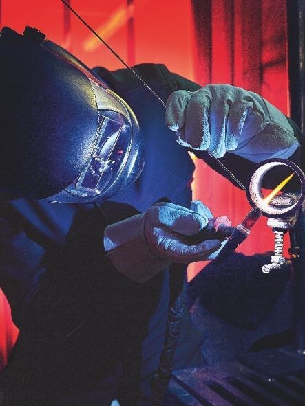 A welder is wearing PPE and is welding.
