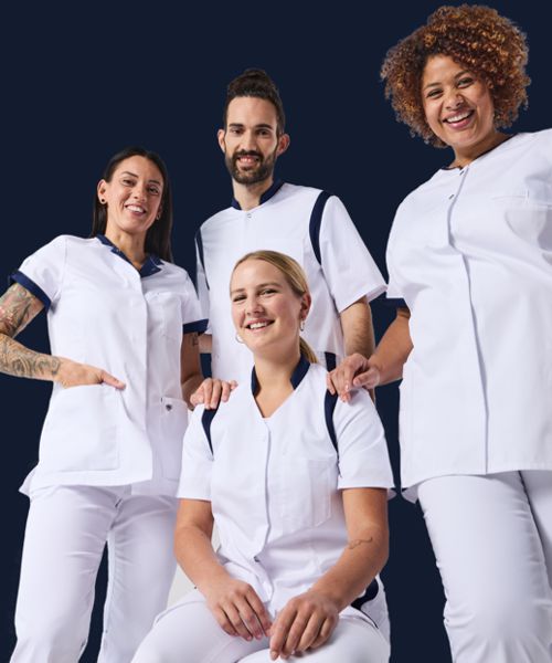 Vier Pflegekräfte posieren in weißer BP Pflegekleidung.