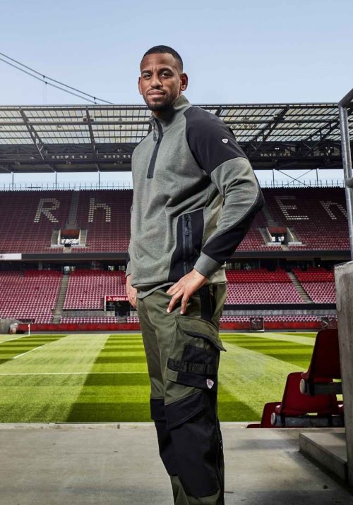 Ein Greenkeeper mit BP® Arbeitskleidung steht an einem Eingang im Rheinenergiestadion.