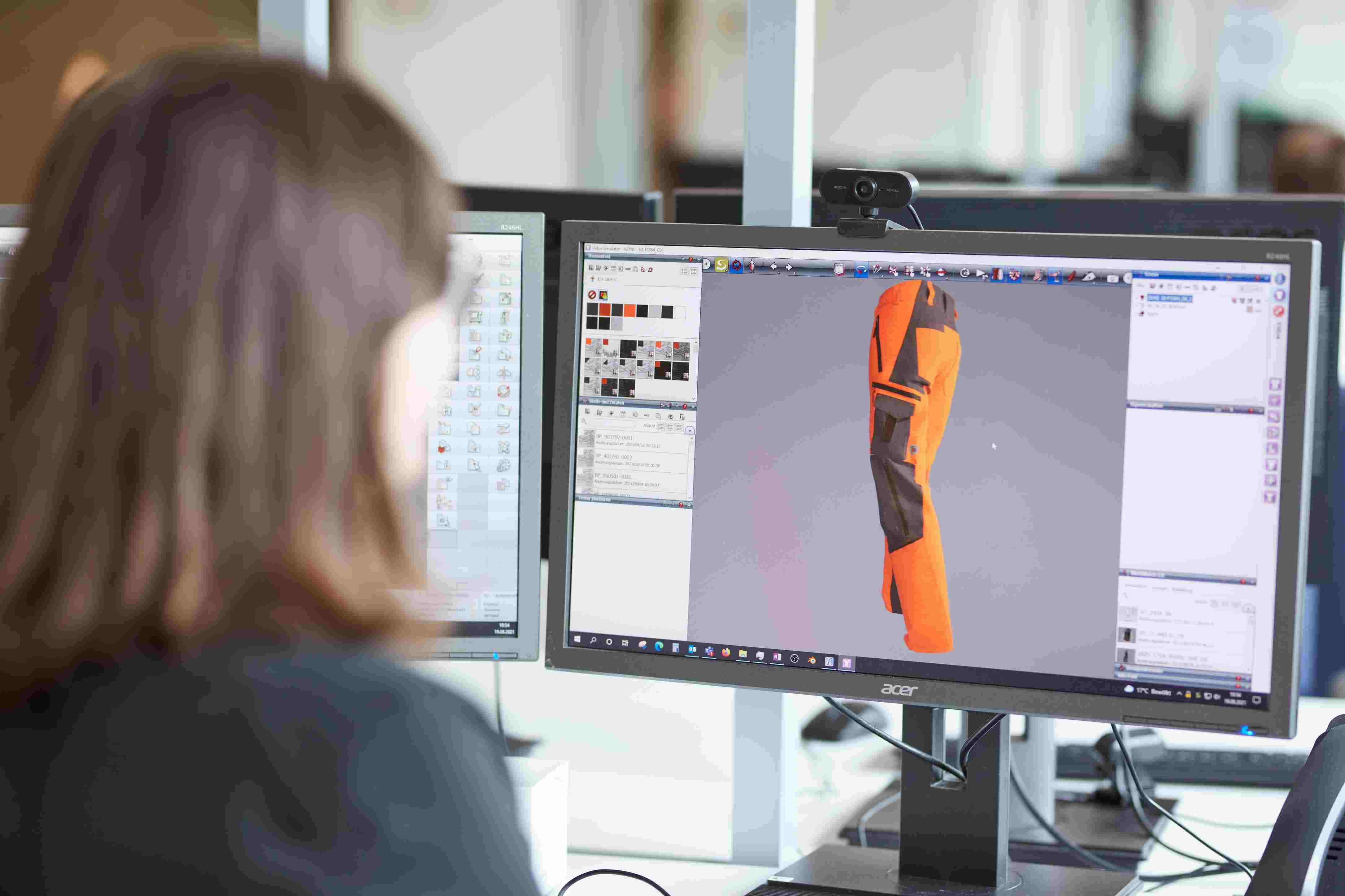 BP® Mitarbeiterin schaut sich 3D Animation einer Arbeitshose auf dem Monitor an.