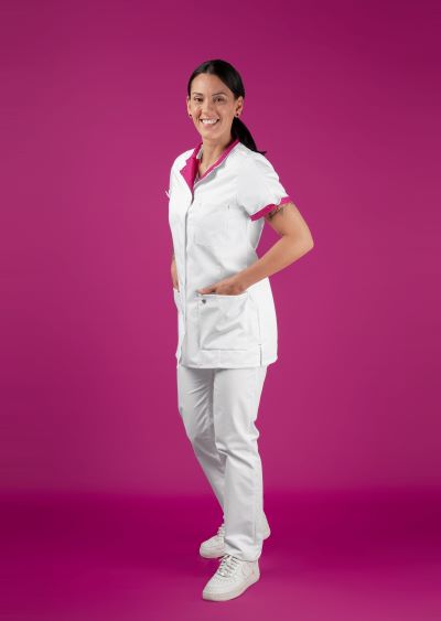 A woman wears a pink and white tunic.