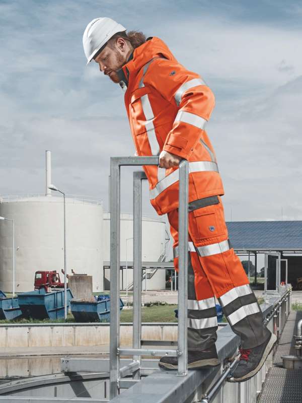 Ein Mann auf einem Dach trägt Multinormwarnschutz-Störlichtbogen Kleidung.