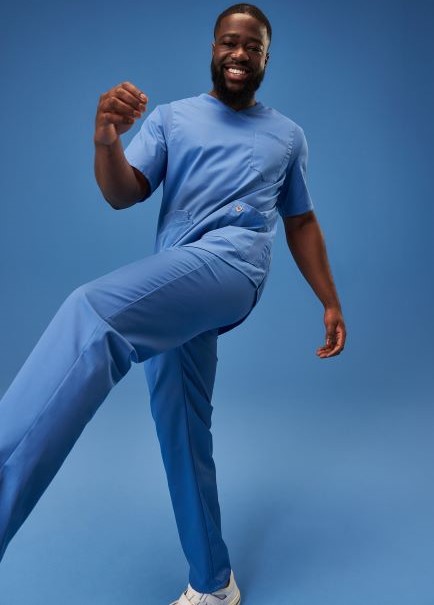 Ein Pfleger trägt ein Outfit in azurblau.