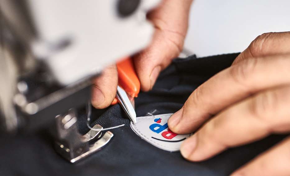 Ein BP® Logo wird an Kleidung gestickt.
