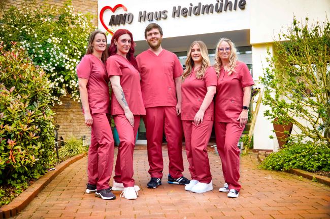 Ein Team aus 5 Pflegekräften der AWO Haus Heidmühle in roter BP Pflegekleidung.
