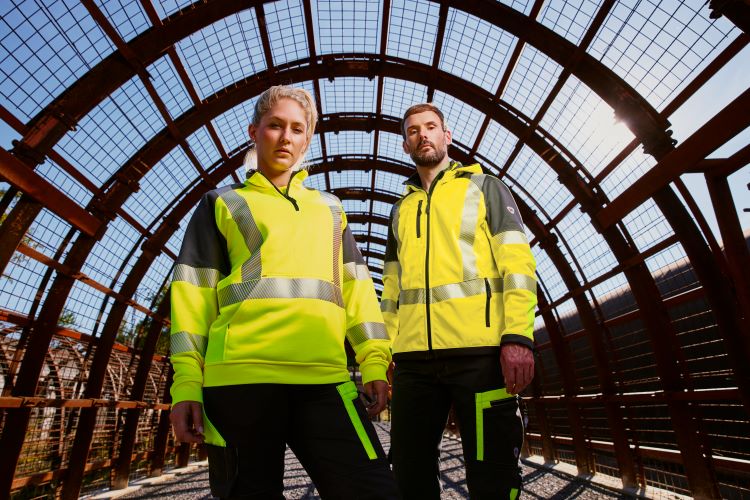 Twee industriearbeiders. Een vrouw en een man in neongeel hivis-waarschuwingspak.