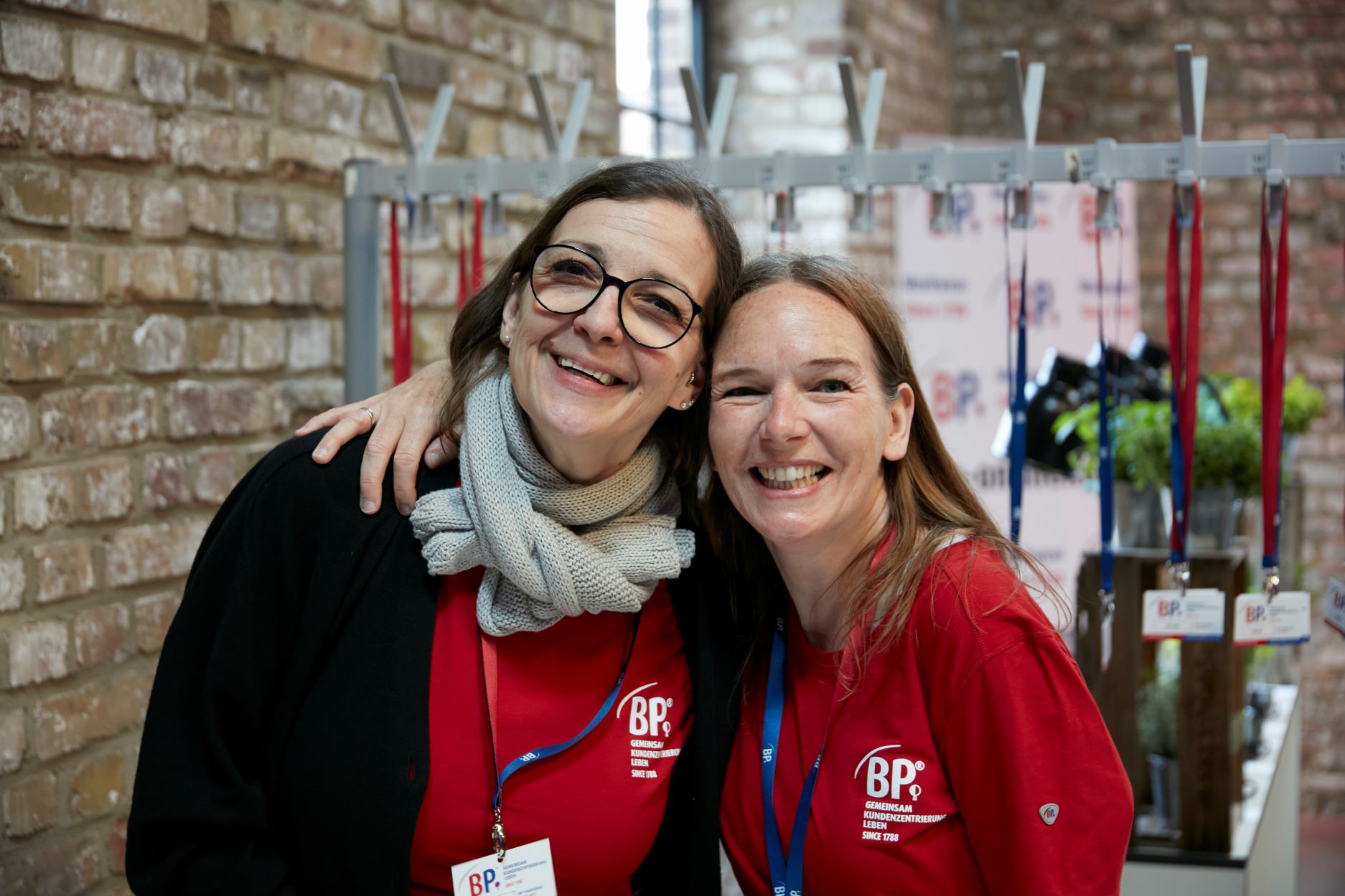 Two BP® employees embrace at a company event.