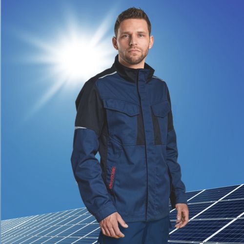 Handwerker in Multinormkleidung vor Solaranlage.