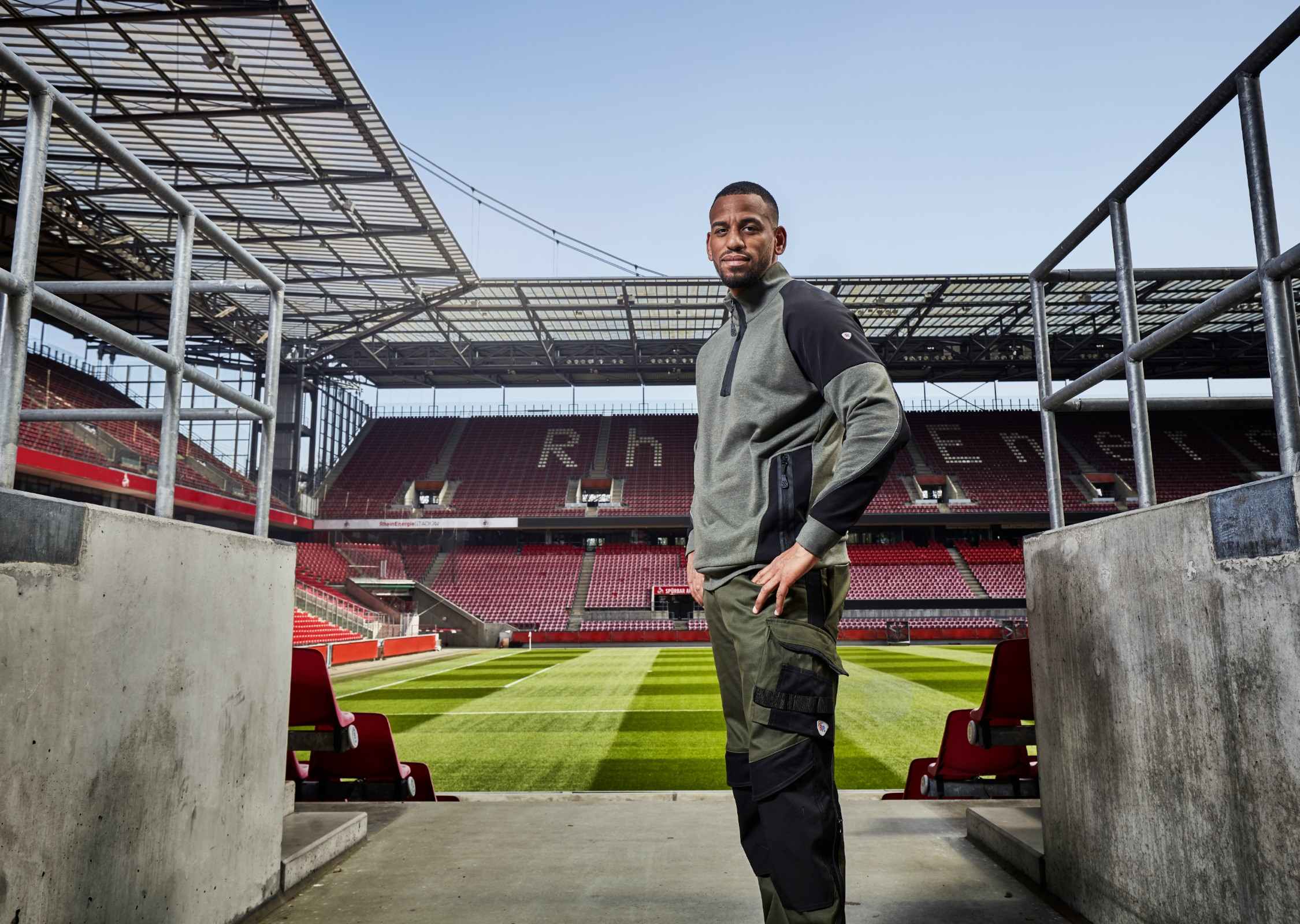 Ein Greenkeeper mit BP® Arbeitskleidung steht an einem Eingang im Rheinenergiestadion.