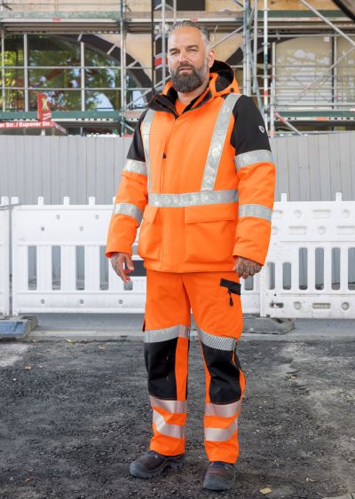 Bauarbeiter in dicker Warnschutzkleidung in Orange.