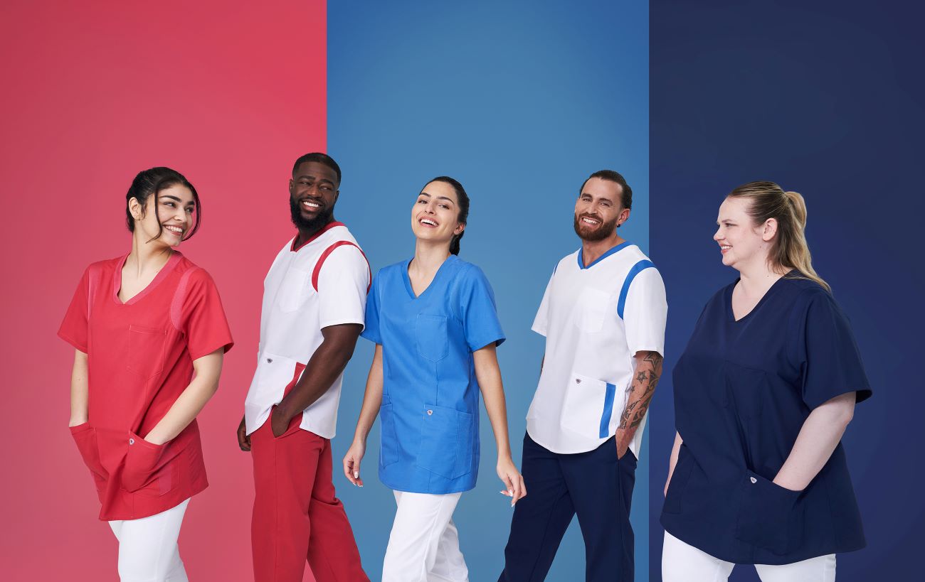 Fünf Pfleger und Pflegerinnen sind in verschieden Schlupfkasacks und Arbeitshosen eingekleidet.