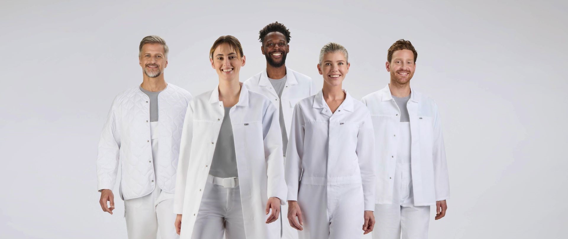 Ein fünfköpfiges Team trägt weiße HACCP Arbeitskleidung.