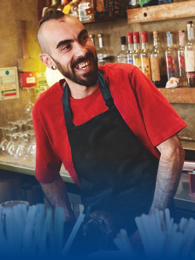 Barista lächelt und trägt schwarze Serviceschütze.
