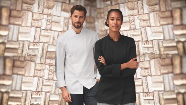Une femme porte une veste de cuisine en noir et un homme porte une veste de cuisine en blanc.