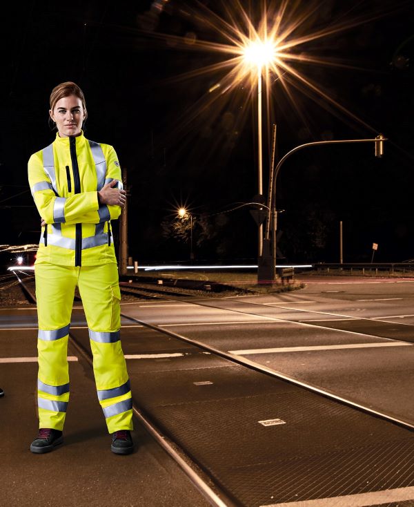 Een vrouw in beschermende kleding met hoge zichtbaarheid 's nachts.