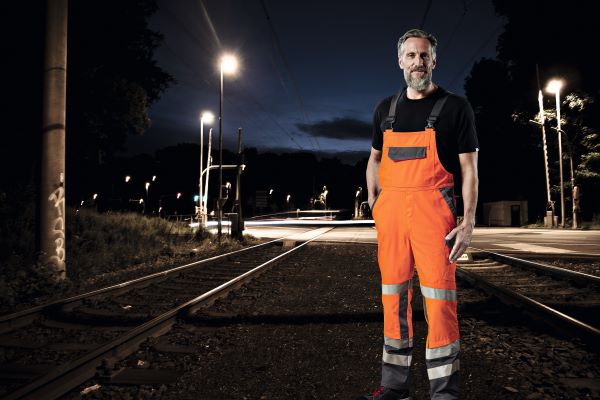 Gleisarbeiter trägt Signalkleidung während der Nachtschicht.