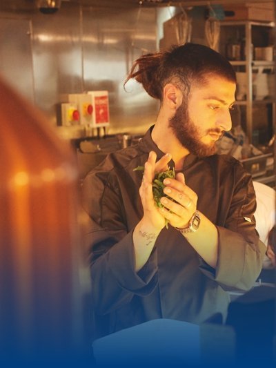 Ein Barista trägt Servicekleidung.