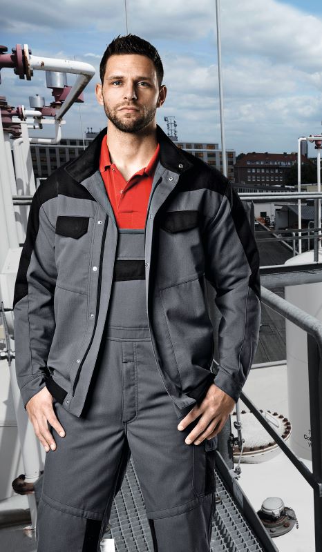 Un soudeur porte une salopette Multinorm et se tient sur le toit d'un bâtiment.