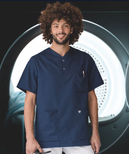 Verzorgster in een donkerblauwe tuniek voor een grote wasdroger.