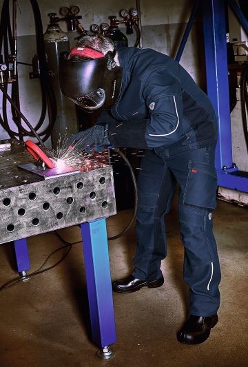 Een man is aan het lassen en draagt lasbeschermingsmiddelen volgens en iso 11611.