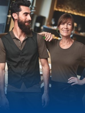 Twee medewerkers in gestandaardiseerde cateringwerkkleding in het servicegebied.