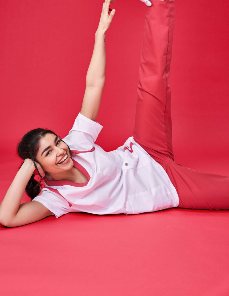 Infirmière en uniforme rouge et blanc faisant du yoga.