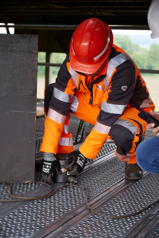 Ein  Instandsetzungstechniker bei DB InfraGO bei der Wartungsarbeit.