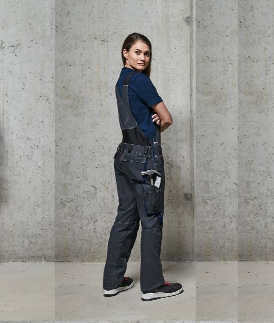 Vrouw in werkbroek voor dames, poseert voor de camera.