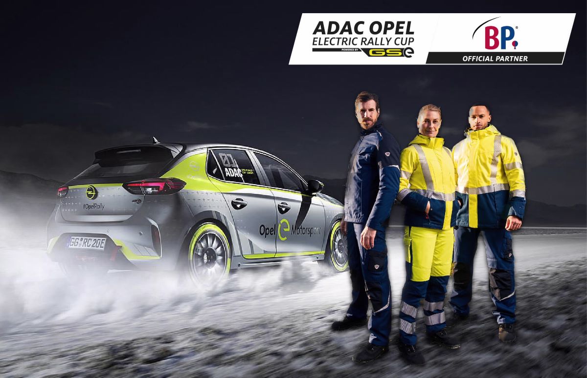 Mechaniker in Schutzkleidung stehen vor Rally-Opel