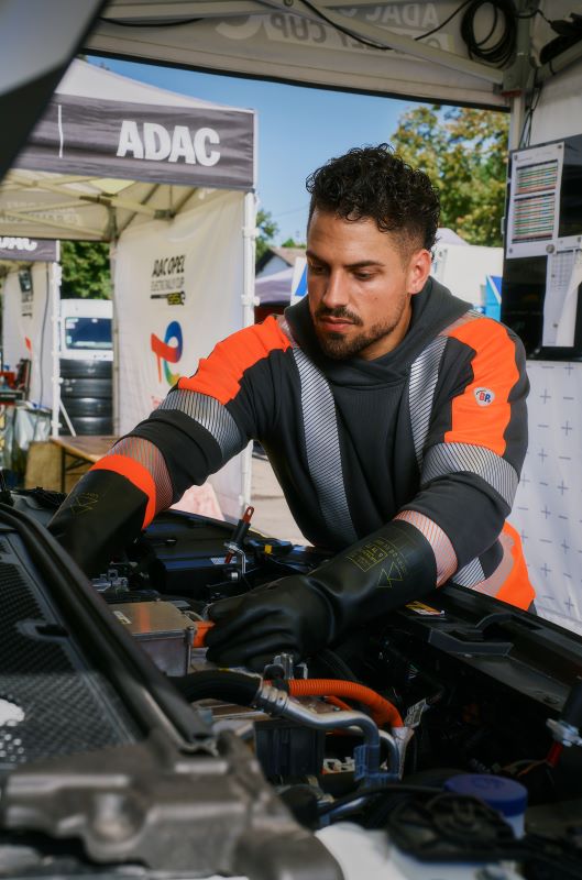 Mann trägt Schutzkleidung von BP® und wartet ein Auto.